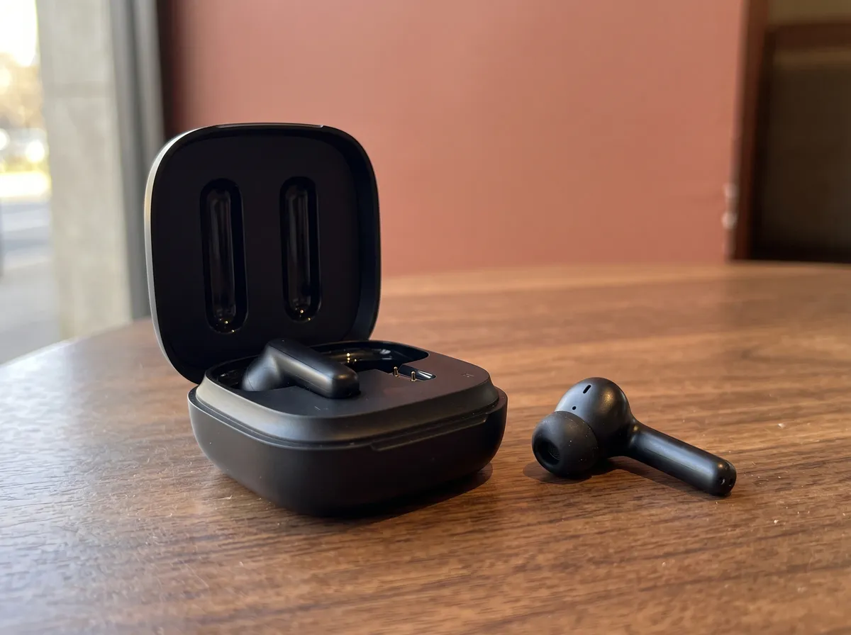 Estojo de fone sem fio aberto sobre uma mesa de madeira