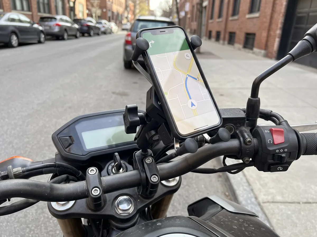 Suporte de moto preso ao guidão segurando um celular com mapa